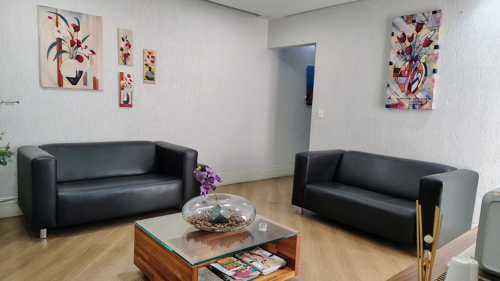 Recepção - área de espera com sofás confortáveis e arte na parede