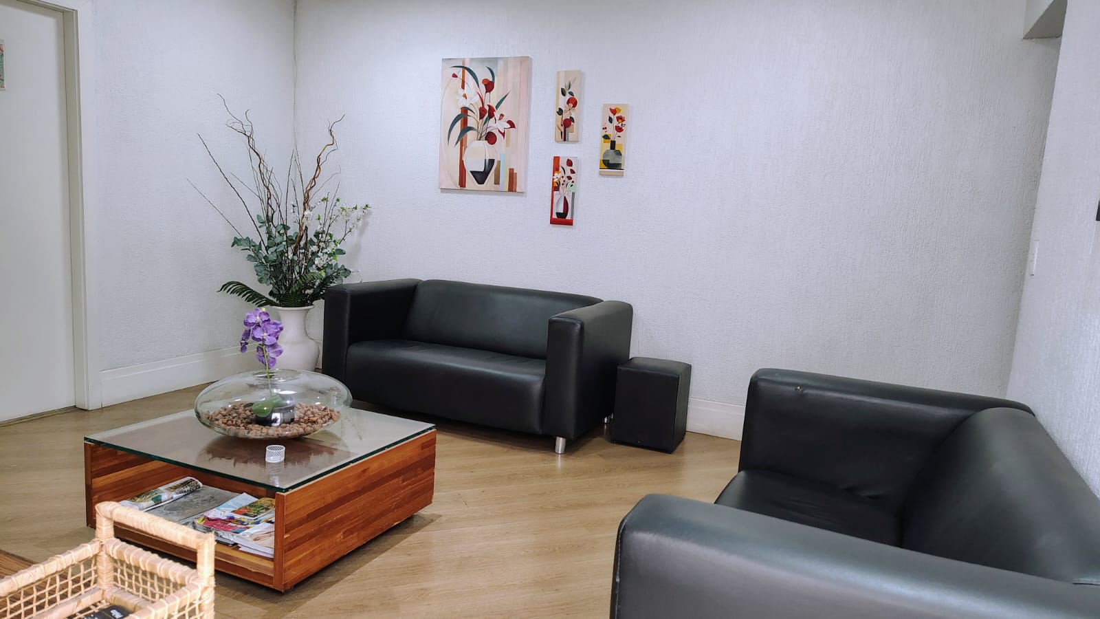 Recepção - sala de espera com sofás de couro preto e decoração moderna